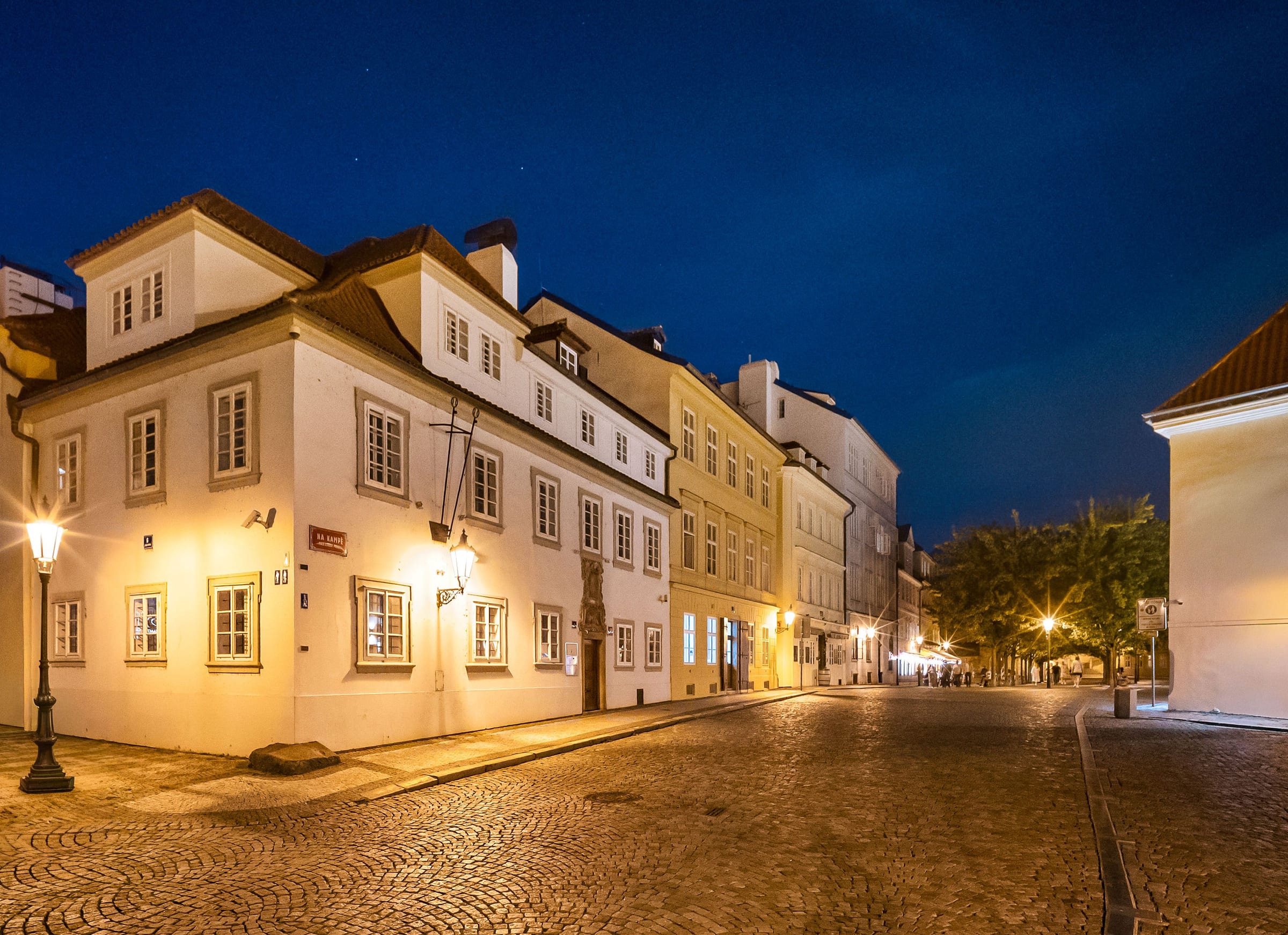 The Blue Fox House in the evening from Na Kampě square, lit by lamps
