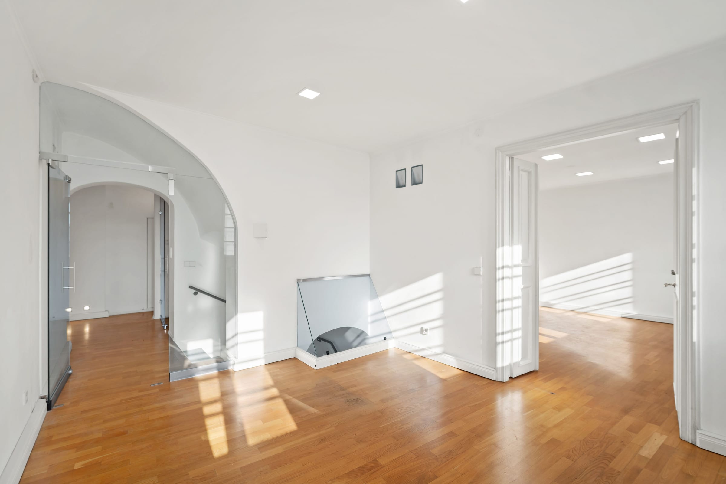First floor: vaulted passages, white walls and oak floor in the sun