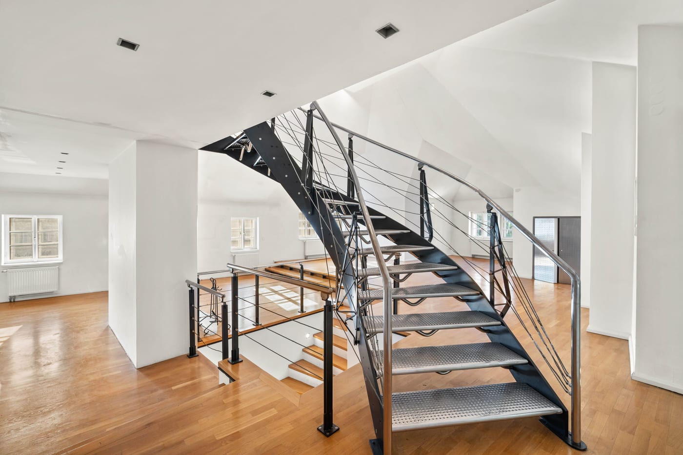 Steel spiral staircase with wooden treads in the attic
