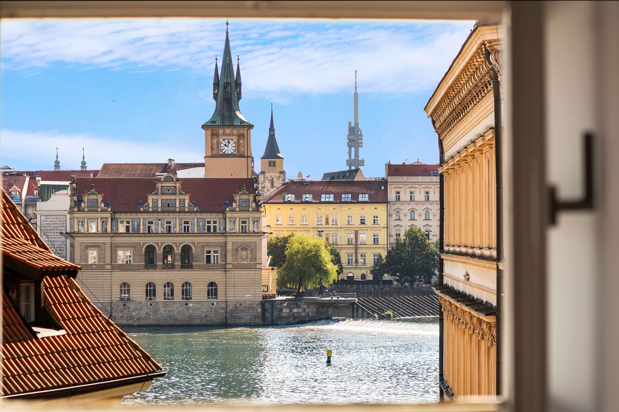 View from an open window over the Vltava to Smetana Embankment and the Old Town Water Tower